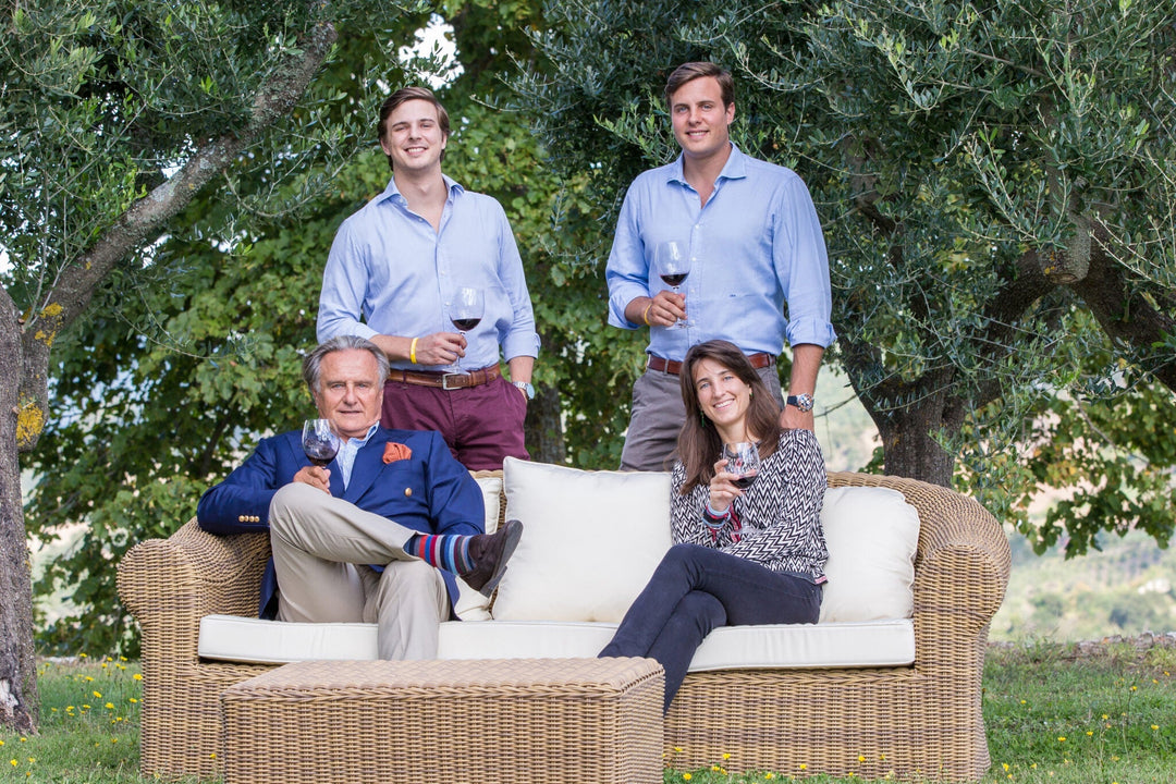 Group enjoying autumn wines castello di montepo on a sunny day in a lush vineyard.