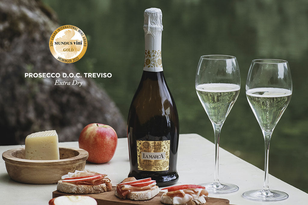 A bottle of La Marca Prosecco D.O.C Treviso with glasses and snacks, representing the best prosecco in America.